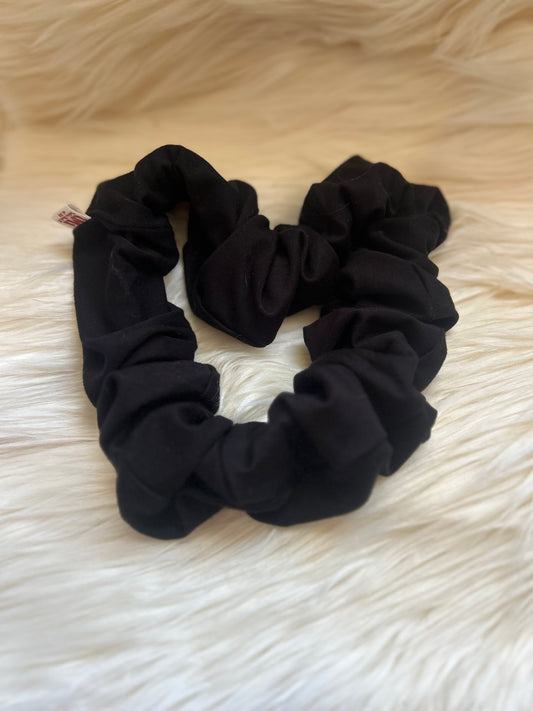 Black scrunchie on a textured white surface