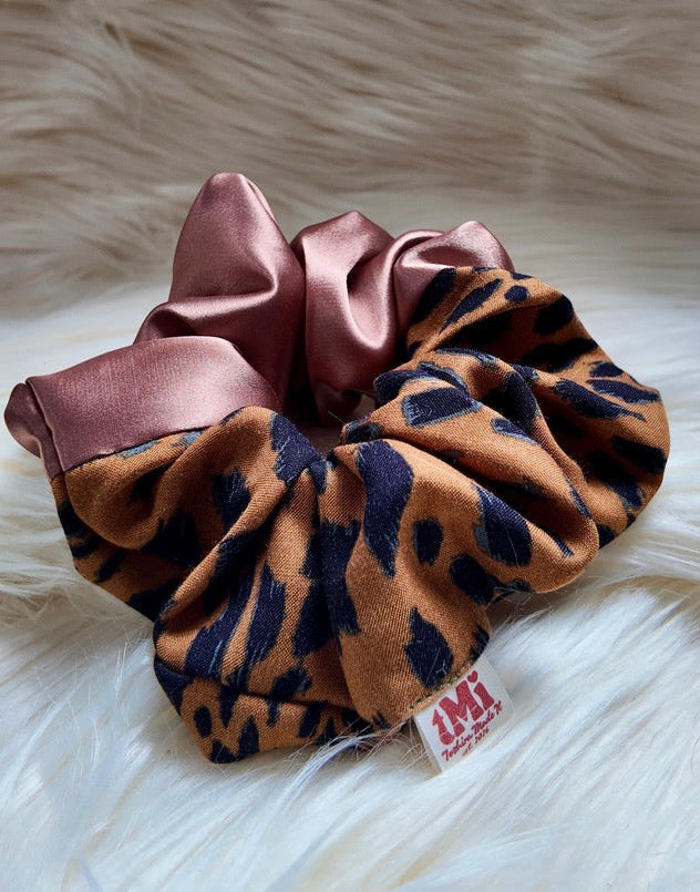 Leopard print scrunchie with copper satin top on a fur background